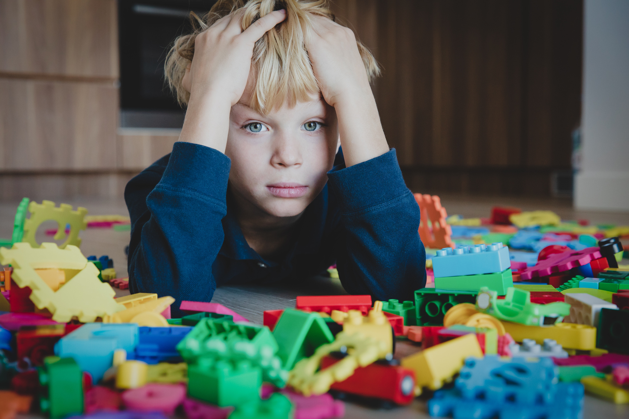 sad child, stress and depression, exhaustion with toys scattered around